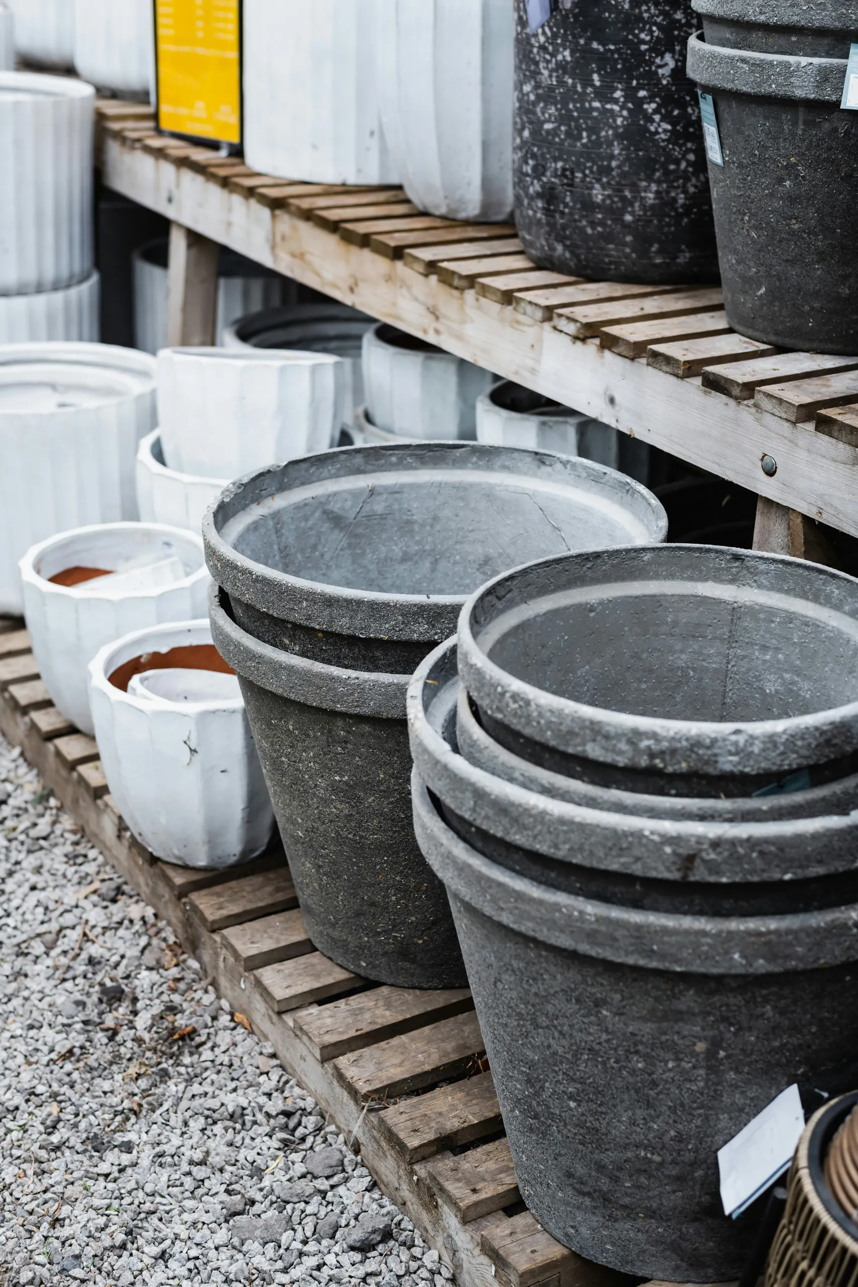 Macetas de cerámica grises y blancas sobre estantes de madera